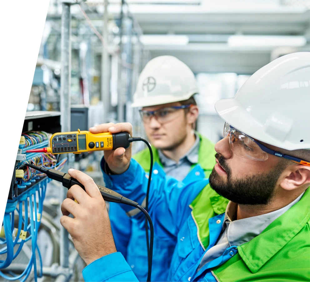 Casqued workers testing an electric&nbsp;panel